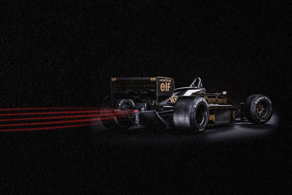 Carro de corrida de Senna correndo rapidamente em um cenário escuro.