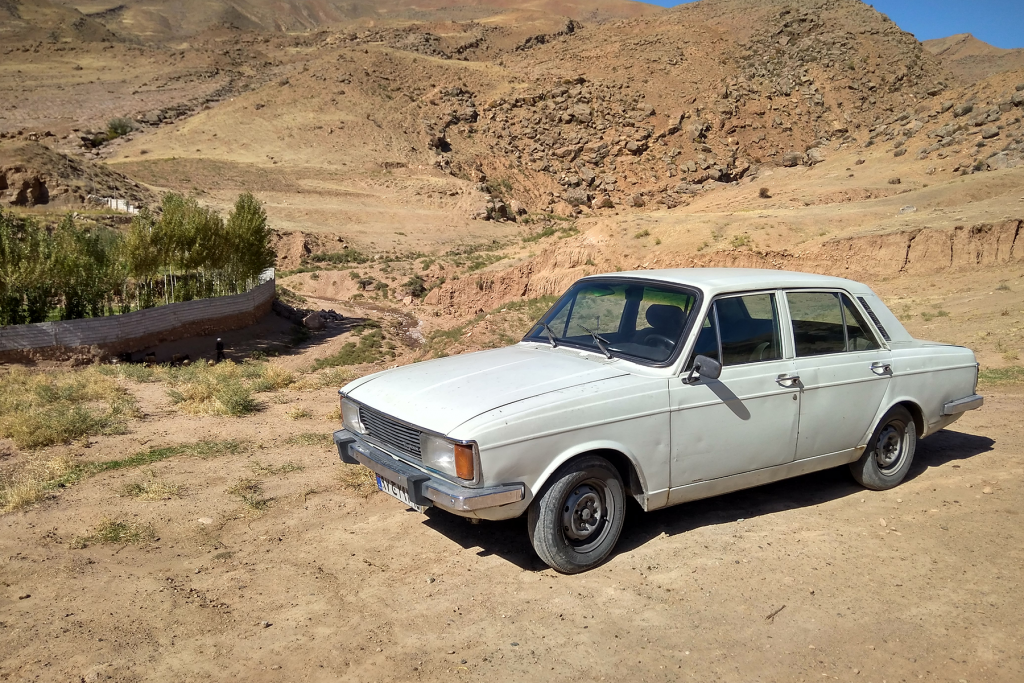 carro branco com nome de time de futebol no deserto.