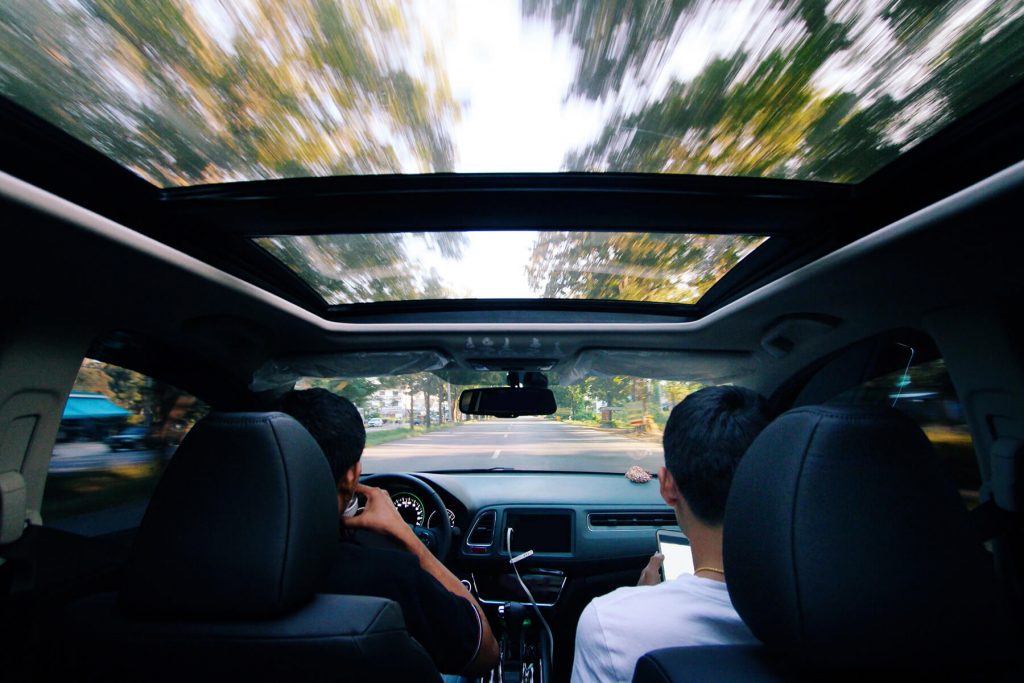 Carro com o teto solar aberto em uma estrada