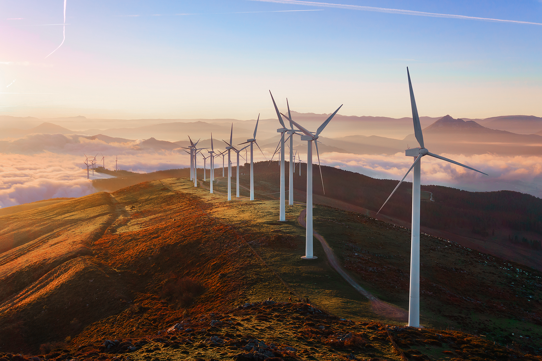 fotografia de cima de um morro com diversas turbinas de produção de energia eólica