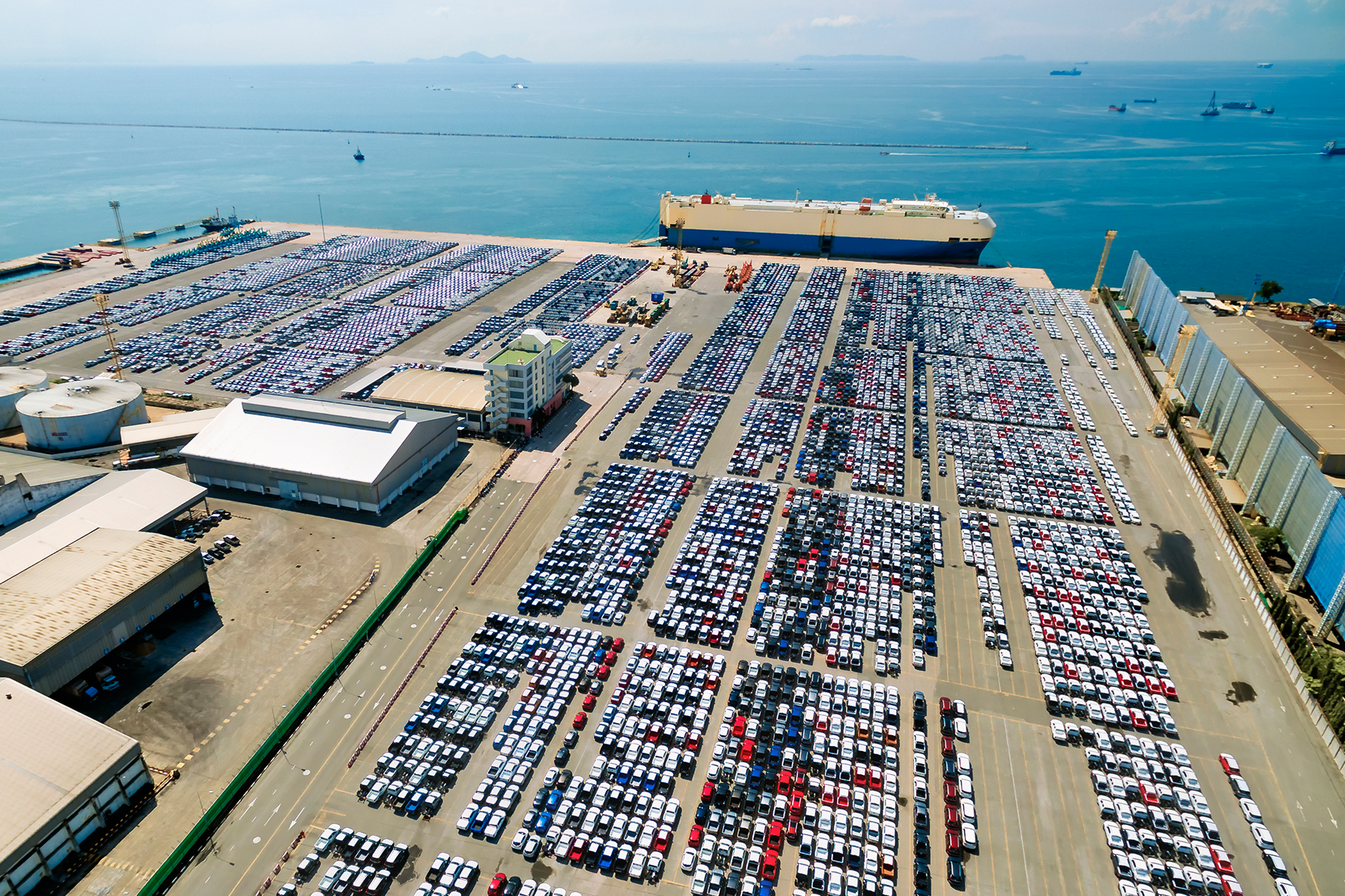 um porto marítimo com diversos carros enfileirados, fazendo uma alusão ao tamanho que uma crise automotiva pode trazer 